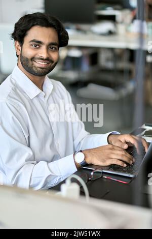 Happy indian young business man employee working on laptop. Portrait Stock Photo