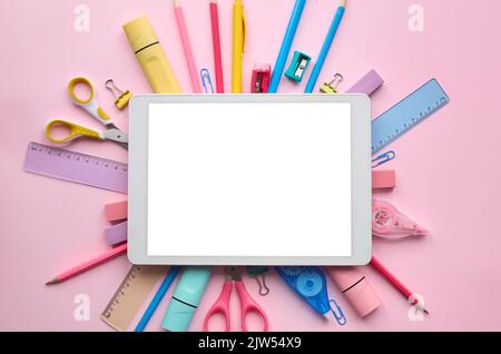 Digital tablet mock up template screen on school stationery pink background. Stock Photo