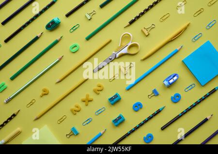 School stationery products in diagonal pattern on yellow background, flatlay. Stock Photo
