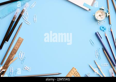 School stationery supplies accessories on blue background, flat lay frame. Stock Photo