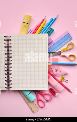 Open notebook and school supplies products accessories on pastel background. Stock Photo