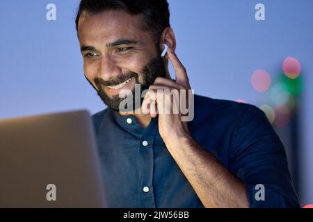 Smiling indian business man having virtual meeting video call at night. Stock Photo