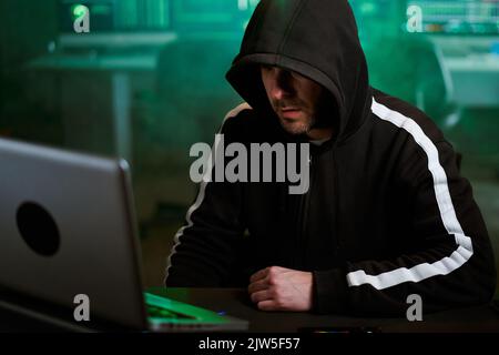 Computer hacker typing code on keyboard late night working and bypassing cyber security. Stock Photo
