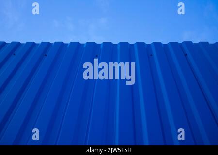 Blue seamless metallic fence with the sky in the background. Stock Photo