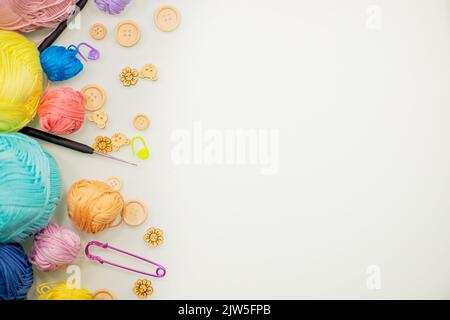 Flat lay composition with knitting threads and hook and buttons on white table, space for text, top view. Stock Photo