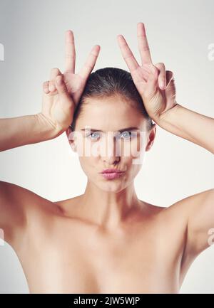 Beauty personified. Studio shot of a beautiful young woman posing against a gray background. Stock Photo