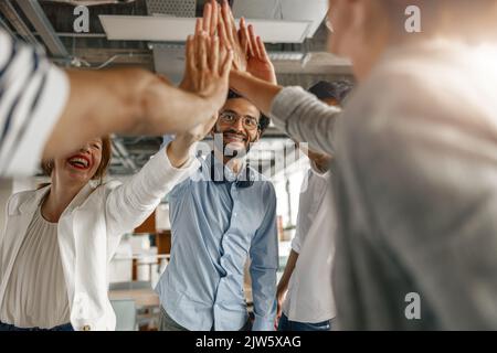 Happy group of multi ethnic coworkers stacked hands together as concept of corporate unity Stock Photo