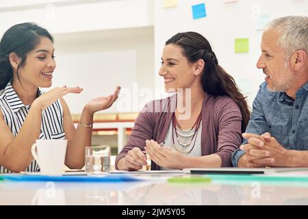 Explaining the goals for their project. a team of colleagues having a meeting in a modern office. Stock Photo
