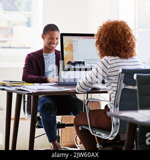 Business is what they do best. colleagues working on their computers in an open plan office. Stock Photo