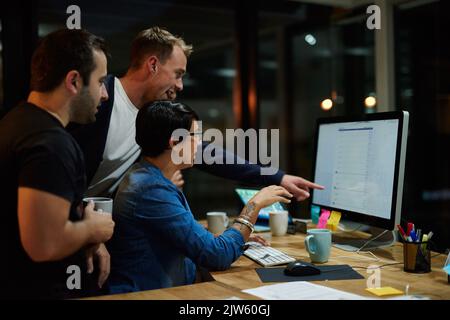 Working on the project together. employees working in an office at night. Stock Photo