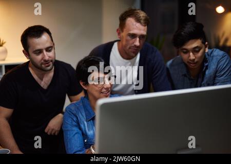 Working on their plans for success. employees working in an office at night. Stock Photo