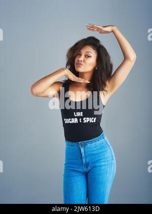 Framing her best feature. Portrait of an attractive young woman posing against a gray background. Stock Photo