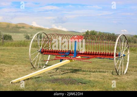 Vintage farm cultivator in a field on the Bar U Ranch National Historic Site, southern  Alberta, Canada. Stock Photo