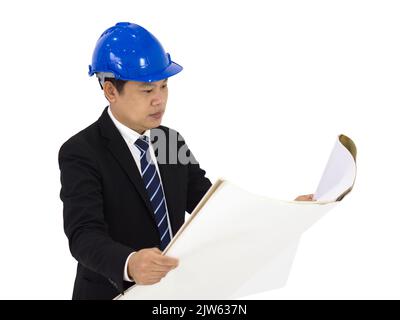 Young businessman in a black suit wearing a blue construction hat, checking the construction drawings of real estate project. Portrait on white backgr Stock Photo