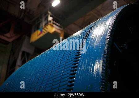 Fragment of a large rotor of a powerful electric motor, extremely close view. The rotor is painted with blue enamel Stock Photo