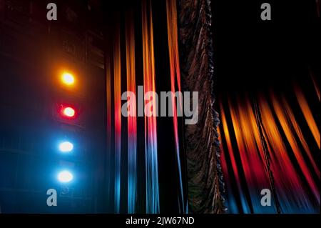 Austrian pleated main front stage curtain under the light of colorful stage floodlights Stock Photo