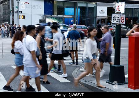 People walk past a “Gun Free Zone” sign posted near Bryant Park at one of the access points to Times Square on September 3, 2022 in New York City USA. In view of the recent US Supreme Court's ruling, New York State is now a “shall-issue” state, which mandates that anyone who meets all prescribed requirements cannot be denied an open or canceled carry gun permit. However, New York State amended parts of the law setting certain areas of the city as “Gun Free Zones” (Photo by John Lamparski/SIPA USA) Credit: Sipa USA/Alamy Live News Stock Photo