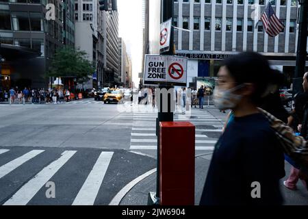 People walk past a “Gun Free Zone” sign posted near Bryant Park at one of the access points to Times Square on September 3, 2022 in New York City USA. In view of the recent US Supreme Court's ruling, New York State is now a “shall-issue” state, which mandates that anyone who meets all prescribed requirements cannot be denied an open or canceled carry gun permit. However, New York State amended parts of the law setting certain areas of the city as “Gun Free Zones” (Photo by John Lamparski/SIPA USA) Credit: Sipa USA/Alamy Live News Stock Photo