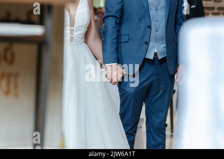 Bride and Groom holding hands during their wedding ceremony Stock Photo