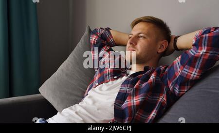 A young man resting on the couch. Happy man relaxing at home Stock Photo