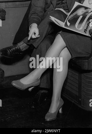 Image of two women's legs in a train compartment. N.B. The photo is made for advertising purposes, possibly for shoes or nylon stockings. Stock Photo