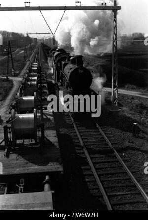 Image of a freight train drawn by two steam locomotives from the series 3700/3800 of the N.S., seen from an overhead mounting car wagon during electrification work on a railway line. Stock Photo