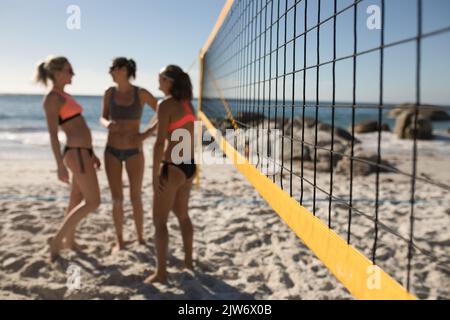 Female volleyball players discussing on the beach Stock Photo