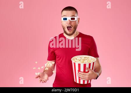 young man in 3d glasses throwing up and eating popcorn Stock Photo