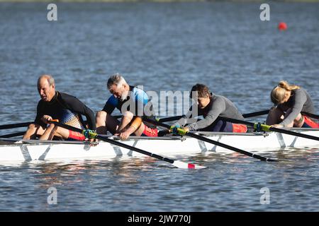 Tired senior caucasian rowing team taking a break from rowing the boat on the lake Stock Photo