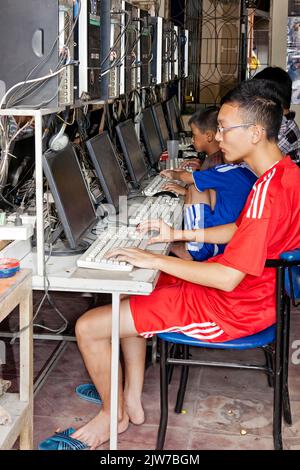 Young students working on computer in internet shop, Hai Phong, Vietnam Stock Photo