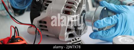 Master repairman diagnosing breakdown of car generator using tester closeup Stock Photo