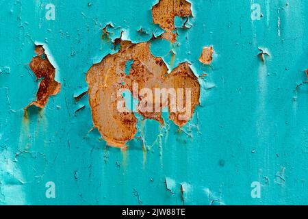 Brown rust with peeling blue paint on old metal fence Stock Photo