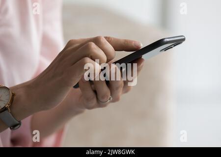Smartphone user woman touching screen, typing, using online app Stock Photo