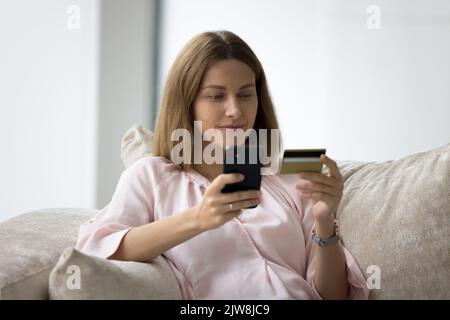 Millennial woman using ecommerce shopping app on mobile phone Stock Photo