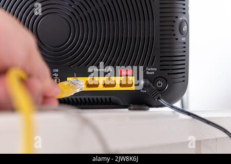 A person connecting a device to a internet router. Stock Photo