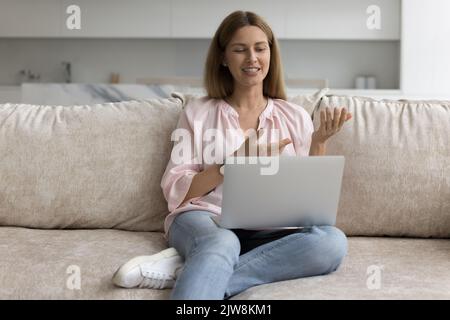 Positive attractive 30s laptop user woman resting on home sofa Stock Photo