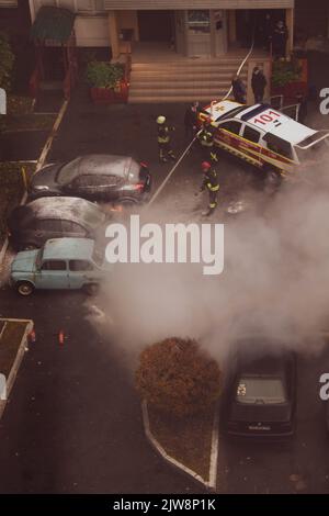 Kyiv, Ukraine. 7 October 2021. Firefighters emergency extinguishing burning car parked in yard of apartment building. Emergency situation. Insurance e Stock Photo