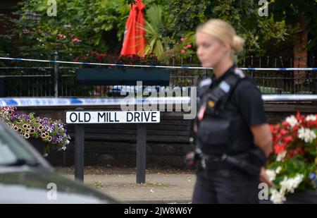 Police officers stand near the scene on at Place de Villerest on the junction of Old Mill Drive and the High Street in Storrington, West Sussex, after a man died. A 68-year-old man has been arrested on suspicion of murder police said. Picture date: Sunday September 4, 2022. Stock Photo