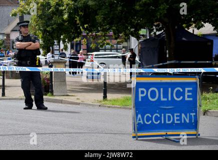 Police officers stand next to a police tent at the scene on at Place de Villerest on the junction of Old Mill Drive and the High Street in Storrington, West Sussex, after a man died. A 68-year-old man has been arrested on suspicion of murder police said. Picture date: Sunday September 4, 2022. Stock Photo