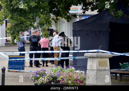 Police officers stand next to a police tent at the scene on at Place de Villerest on the junction of Old Mill Drive and the High Street in Storrington, West Sussex, after a man died. A 68-year-old man has been arrested on suspicion of murder police said. Picture date: Sunday September 4, 2022. Stock Photo