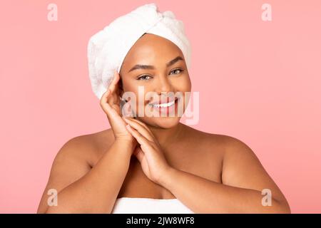 Black Plus Size Female Holding Hands Near Face, Pink Background Stock Photo