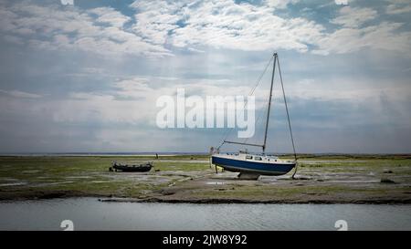 Boats lie stranded on the Thames Estauary at low tide at Leigh-on-Sea, Essex, UK. Stock Photo