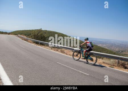 Senior cyclist speeding down the CC-139 winding road. Low motion shot Stock Photo