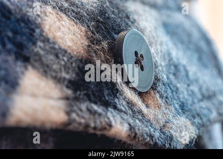 Button on a warm blue shirt, macro shot. Stock Photo