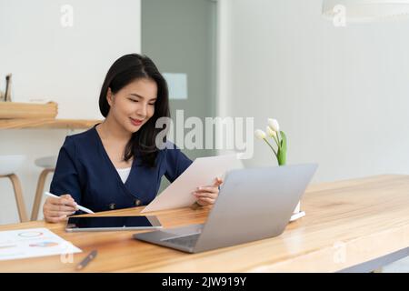 Businesswoman using stylus pen signing contract on digital tablet on office table. Business manager proofing e-document, electronic signature, e Stock Photo