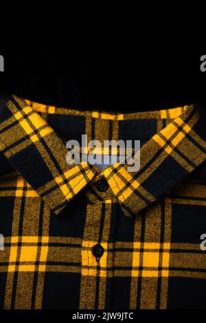 Defocus black and yellow checkered shirt. Gingham tablecloth back pattern. Fragment of a wrinkled squared black and white shirt cloth fabric as a back Stock Photo