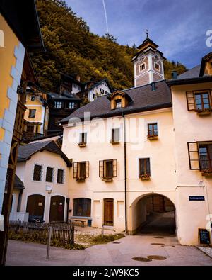 A vertical shot of residential buildings with a church tower in the background. Hallstatt, Austria. Stock Photo