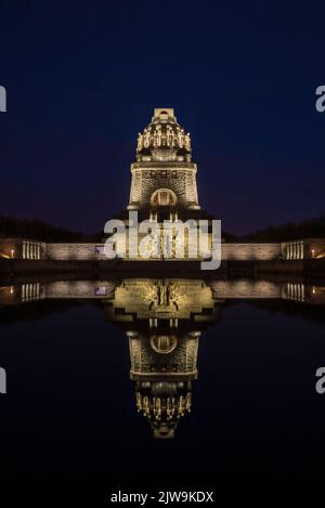 A vertical shot of the Monument to the Battle of the Nations illuminated at night. Leipzig, Germany. Stock Photo