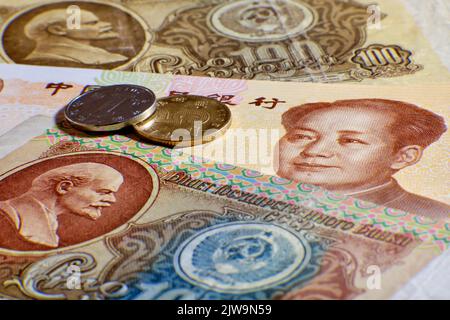 Chinese yuan money and USSR rubles, portrait of Lenin and Mao Zedong close-up. Russia money coin and yuan bill from China Stock Photo
