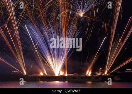 Gorgeous multi-colored fireworks display on dark blue night sky . Stock Photo
